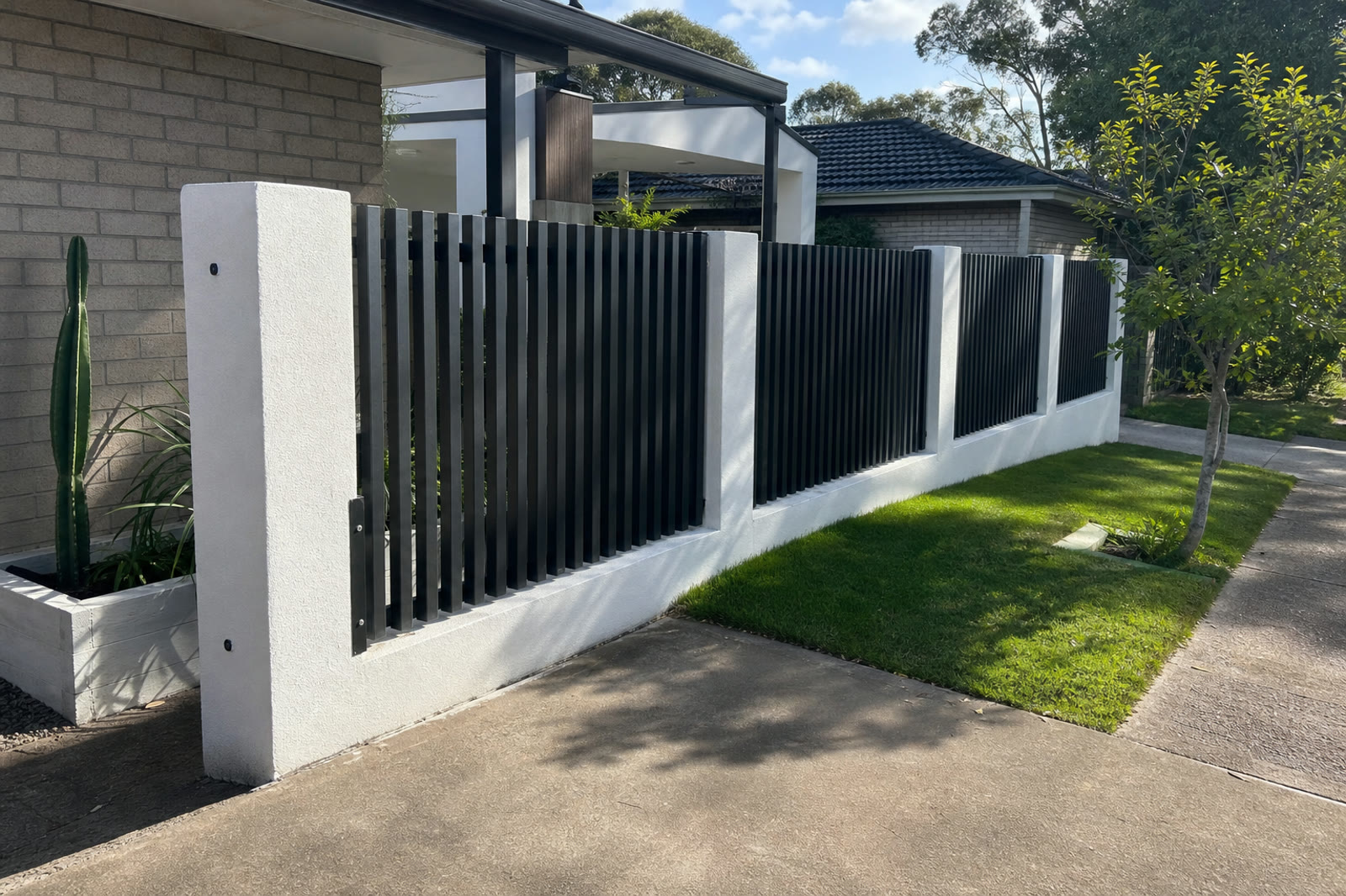 Residential front fencing with black slats and rendered pillars